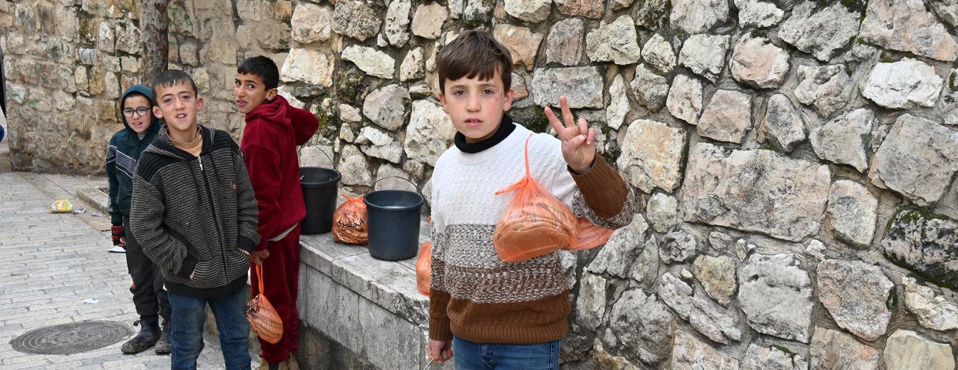 Jungs auf dem Weg zurück vom Einkauf zeigen das Peace-Zeichen / Martina Waiblinger